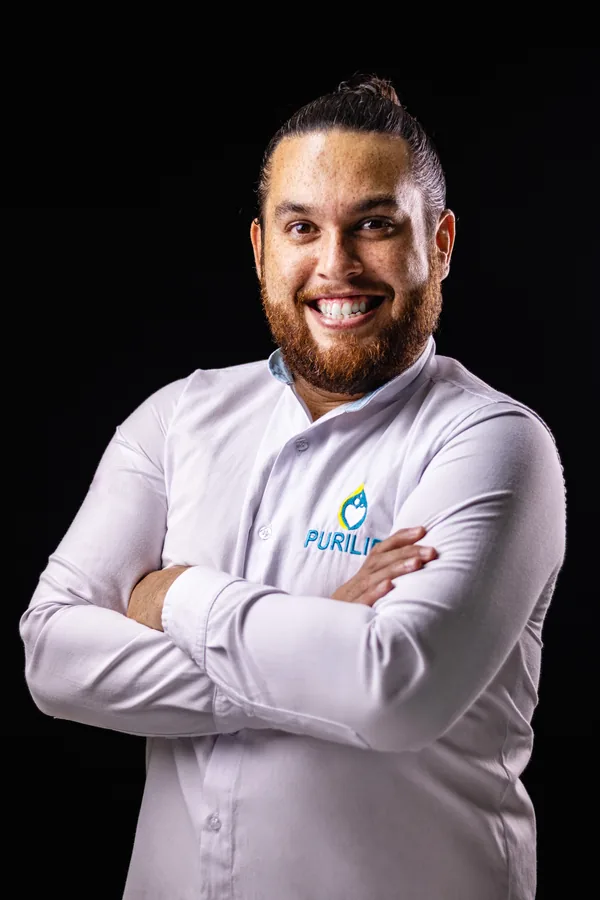 Erick, de Purilife, sonriendo con los brazos cruzados